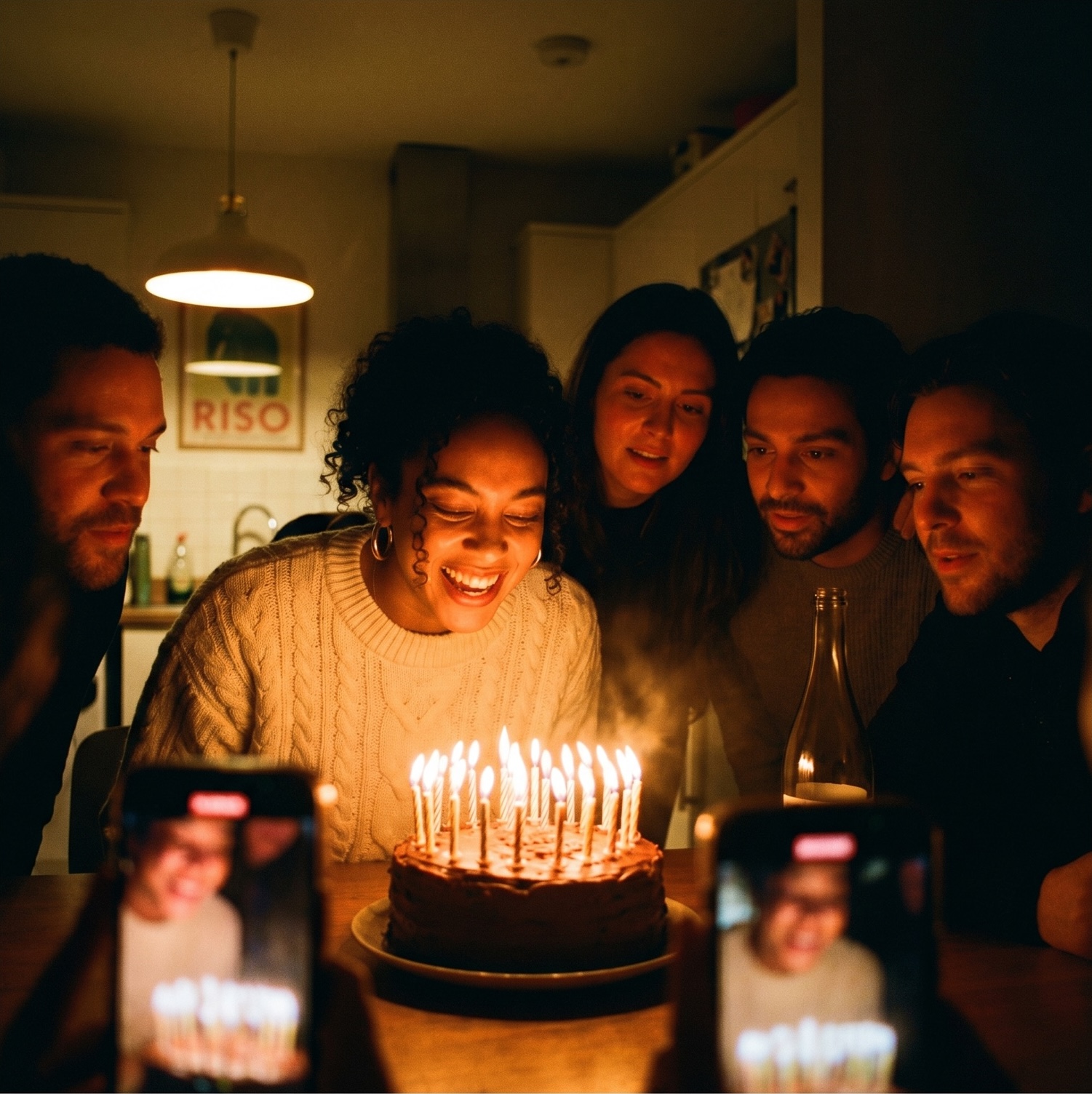 Birthday cake moment, friends gathered with phones capturing it
